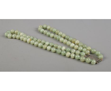 A two row string of jade beads, set with Sterling silver clasp.  