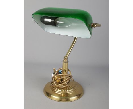 A vintage brass desk lamp featuring green glass shade.  