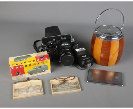 A mixed quantity of collectables including a biscuit barrel, Richmond cigarette case, Zenit 11 camera, Vanguard Reliant Regal