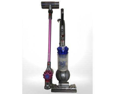 A Dyson V7 motorhead handheld stick vacuum and a Dyson DC41 upright vacuum.