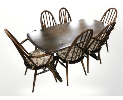 An Ercol stained elm dining table, 150 cm x 77 cm x 72 cm and six matching spindle back dining chairs 