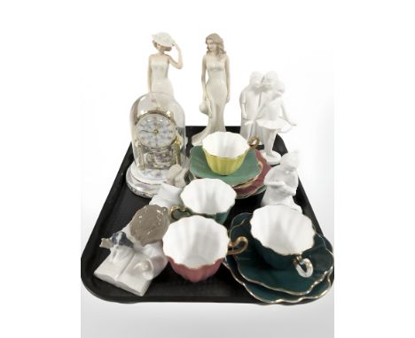 A group of Nao, Coalport and other figurines, Royal Stuart teacups and saucers and an anniversary clock under dome.
