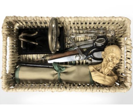 A small wicker basket containing composition anatomical bust, several pairs of scissors, desk magnifier, antique fleam, a can