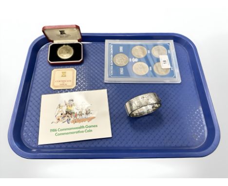 A Pobjoy Mint tercentenary crown, together with a silver bangle, 1986 commonwealth games two pound coin and cased set of Unit
