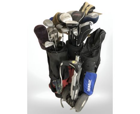 Three golf bags containing irons and drivers including Dunlop, Zucci, Knight etc and a golf bag trolley 