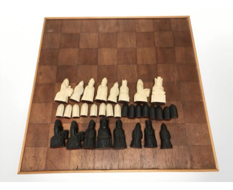 A teak chessboard, width 62 cm and a set of Medieval-style resin pieces, kings 9.5 cm high.