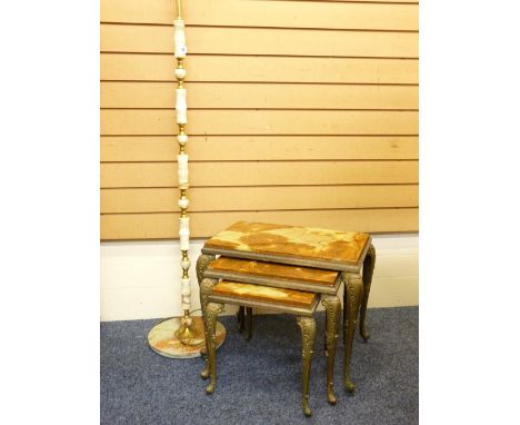 A PSEUDO ONYX AND BRASS STANDARD LAMP with shade on a turned column and circular base and a nest of three metal based coffee 