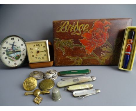 A VINTAGE CARVED AND STAINED LIDDED BRIDGE BOX AND CONTENTS including two silver bladed fruit knives, a mother of pearl handl