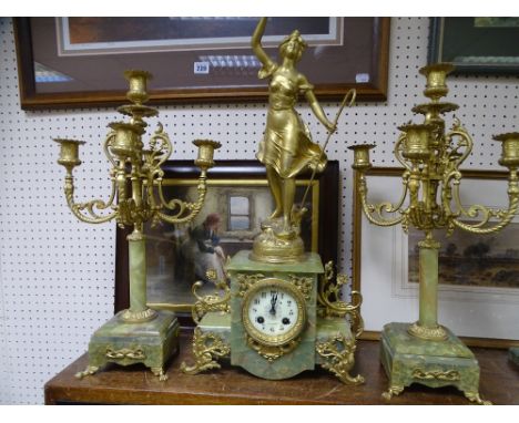 A FRENCH ONYX AND GILT METAL THREE PART CLOCK GARNITURE with Japy movement, central clock with a shepherdess figurine and a p