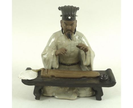 A pair of Chinese mud men figures, early 20th century, one a musician playing a zheng, feather fan at his side, 19 by 18cm, t