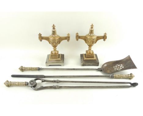 A George III set of brass and steel fire irons, with shovel, poker and tongs, each with decorated brass finial topped grips, 