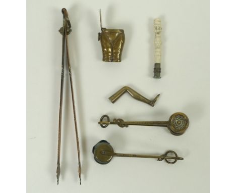 A small collection of Victorian collectables, comprising three pairs of skirt lifters, largest 22cm, a brass pipe tamper mode