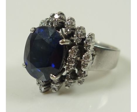 An 18ct white gold, diamond and sapphire dress ring, the central oval royal blue stone of 10 by 12mm and surrounded by 38 dia