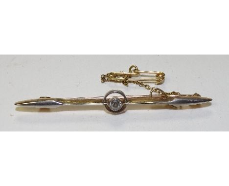 A yellow metal diamond bar brooch, the central brilliant cut diamond measuring approx 0.10ct mounted in circular formation wi