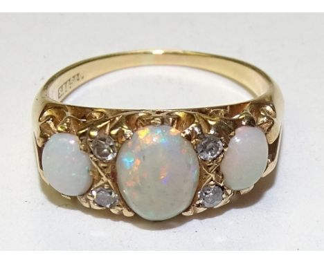 A gold opal and diamond ring, with three graduated oval opal cabochons interspersed by four small diamonds, hallmarks rubbed,