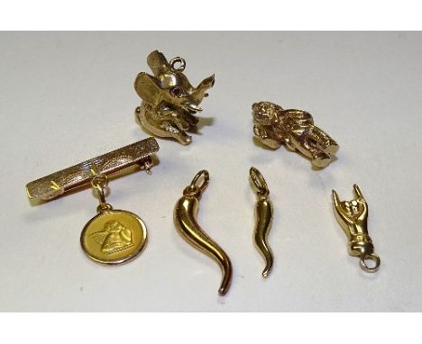 A collection of gold charms, one 18ct gold charm of a winged putti on brooch, stamped 750, two chilli peppers and a hand, all