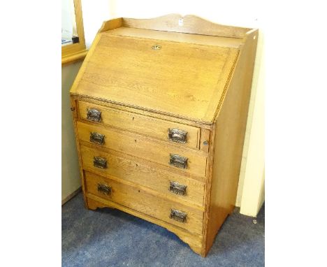 An oak writing bureau, with open shelf above fall front enclosing pigeon holes above four graduated drawers, flanked by pull 