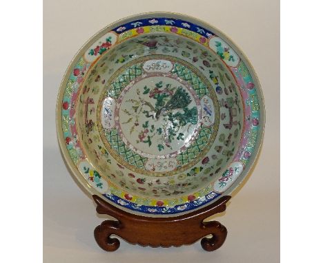 A large 19th century Chinese famille verte bowl, decorated with peacock in foliage amongst multicoloured surroundings and ora