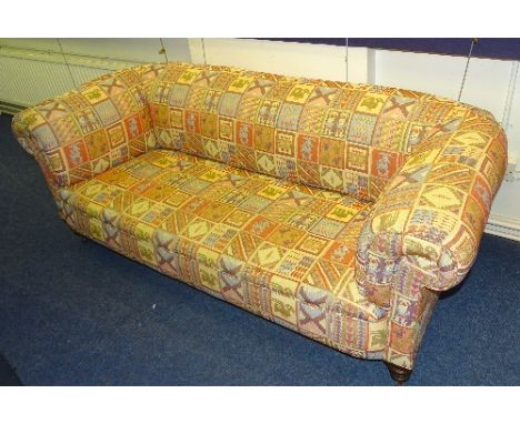 An Edwardian Chesterfield sofa, in later Kelim style upholstery, raised on turned mahogany supports with ceramic castors, 65c