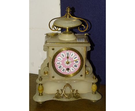 A white onyx mantel clock, the pink and white enamel dial with Roman numerals, pendulum present, 30cm tall