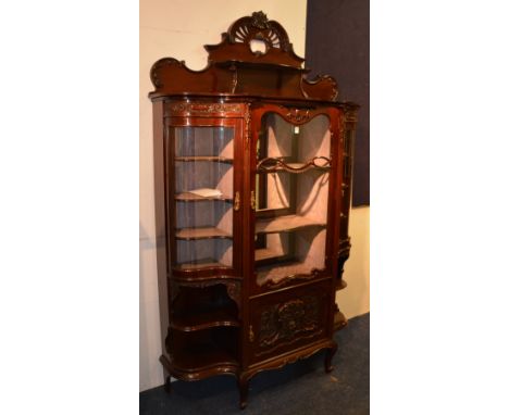 A good quality Edwardian mahogany display cabinet, with carved scroll pediment and gallery shelf above glazed door and carved