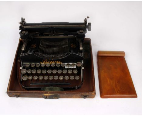A travelling typewriter and bakerlite notepad