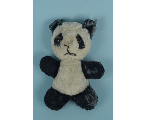 A small Steiff style panda, with hole in left ear, glass eyes, 12cm long (in playworn condition)