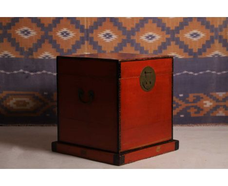 A red lacquer trunk, c.1920, Chinese, with black line border and curcular brass lock plate,42cm square48.5cm highCondition Re