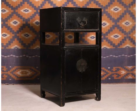A Japanese black lacquer cabinet, c.1900, with drawer, shelf and cupboard, iron handle and lockplate, on shaped feet,42cm squ