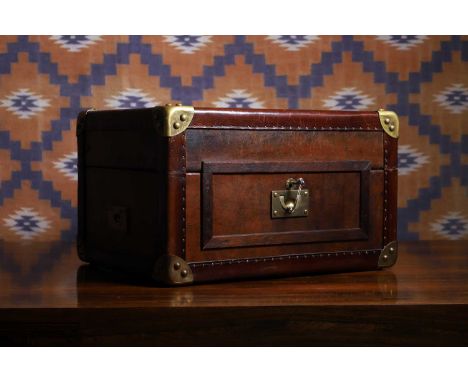 A patinated leather trunk, 20th century, with brass handles, corners and lock plate,44cm wide34cm deep26cm high