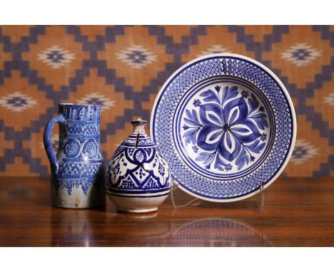 A group of Moroccan blue and white pottery, comprising a late 19th century ghorraf pitcher,14cm wide20cm high,a Maastricht bl