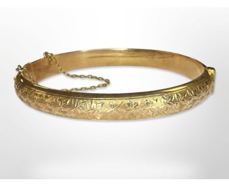 An antique 15ct yellow gold bangle, with lightly engraved floral decoration, internally 6 cm x 5 cm. CONDITION REPORT: 10.4g.