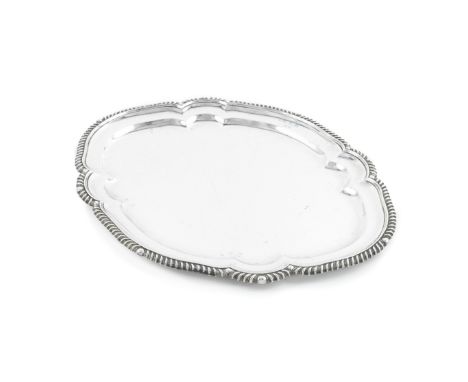 A silver meat platterRichard Woodman Burbridge, stamped 'Harrods', London 1929Shaped-oval form with gadroon rim, the border w