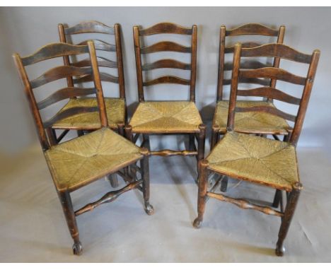 A Set Of Five 19th Century Country Ladder Back Dining Chairs With Rush Seats, raised upon turned legs with pad feet 