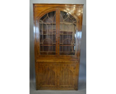 A 19th Century Mahogany Library Bookcase With Two Arched Astragal Glazed Doors enclosing shelves, the lower section with two 