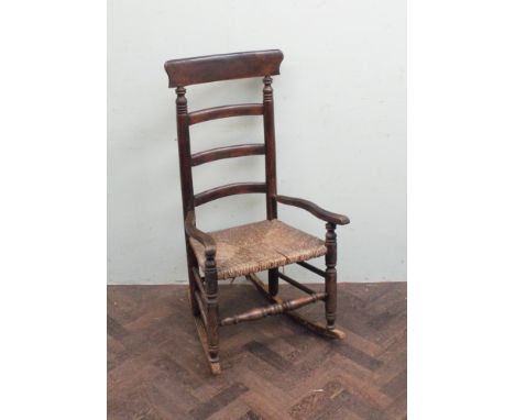 Early Victorian ladder back rocking elbow chair with rush seat 