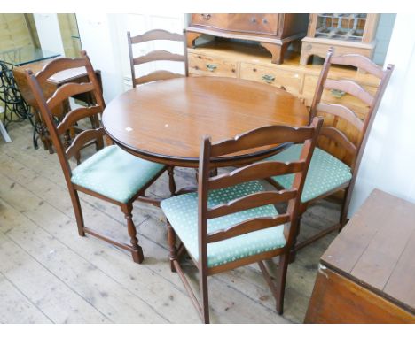 Circular oak single pillar dining table and four ladder back style chairs with green seats to match 