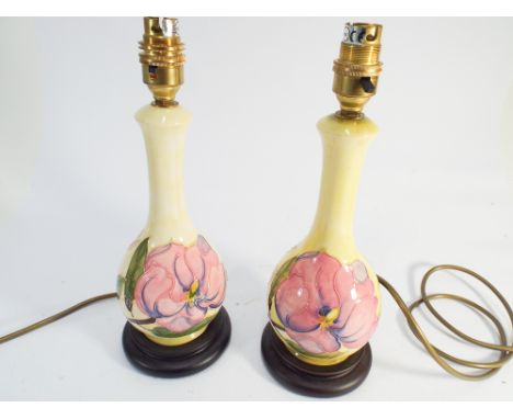 A pair of Moorcroft lamp bases modelled with Amaryllis on a pale lemon ground height including base and light fitting 12" tal