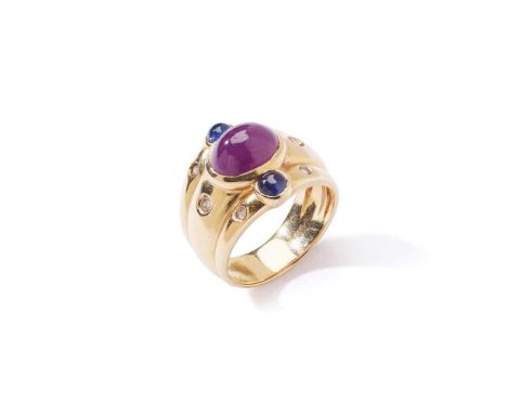 A gem-set dress ring The oval cabochon ruby collet-set between two cabochon sapphires, to a reeded band inset with brilliant-