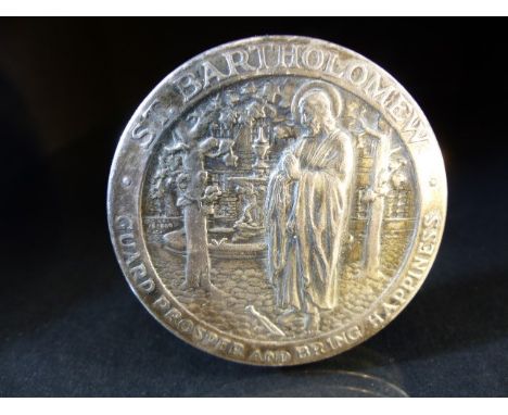 White metal pin cushion, of circular form, the top embossed with St. Bartholomew in a garden setting and the words `Guard Pro