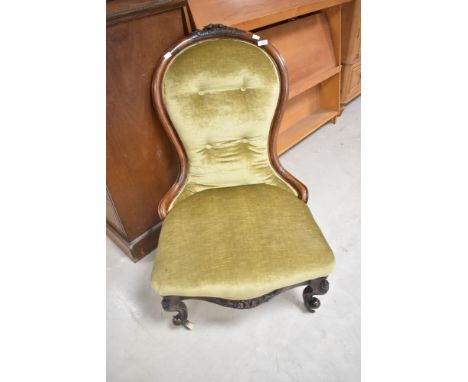 A Victorian mahogany framed nursing chair having green dralon upholstery with button back