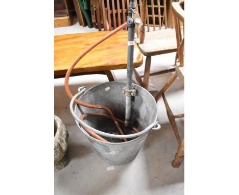 A vintage galvanised bucket having integral pump