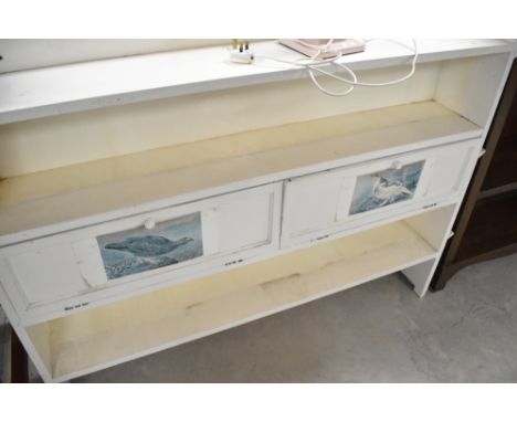 A vintage painted shallow bookshelf with flapped storage sections to centre shelf, width approx. 135cm
