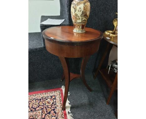 of circular form, the moulded and cross banded top above a plain frieze, resting on a tripod base with a shelf stretcher