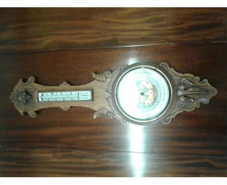 of banjo form, the oak case enclosing a thermometer and a circular barometer