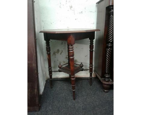 the shaped top raised on turned tapering legs, joined by a shelf stretcher
