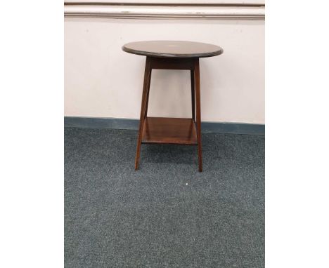 the circular top above splayed square cut supports all joined by a shelf stretcher