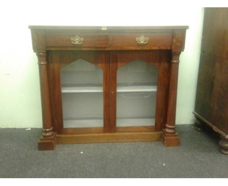 the moulded top above twin drawers and two glazed panel doors, raised on a plinth base