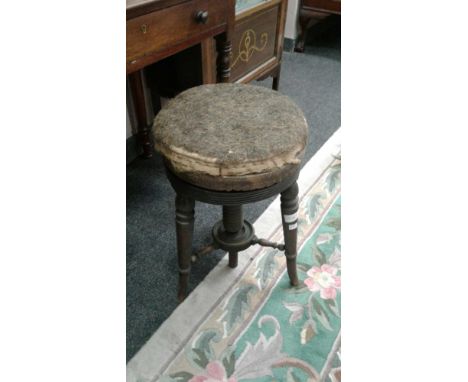 the circular adjustable top above turned tapering legs, joined by a shelf stretcher