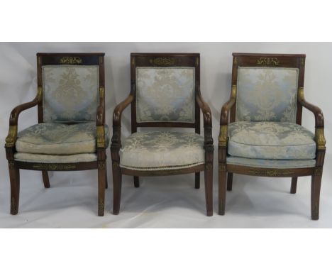 THREE EMPIRE PERIOD MAHOGANY ARMCHAIRS a matching pair with gilt metal mounts and scroll arms, carved with dolphin heads and 